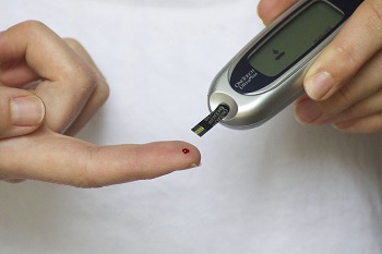 This is a picture of a person using a Glucose meter, a machine to check and  monitor blood sugar level.