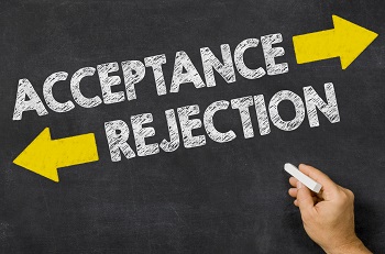 This is a picture of a black chalkboard. A person has written the word, Acceptance, with an arrow pointing forwards, and the word, Rejection, with an arrow pointing backwards.