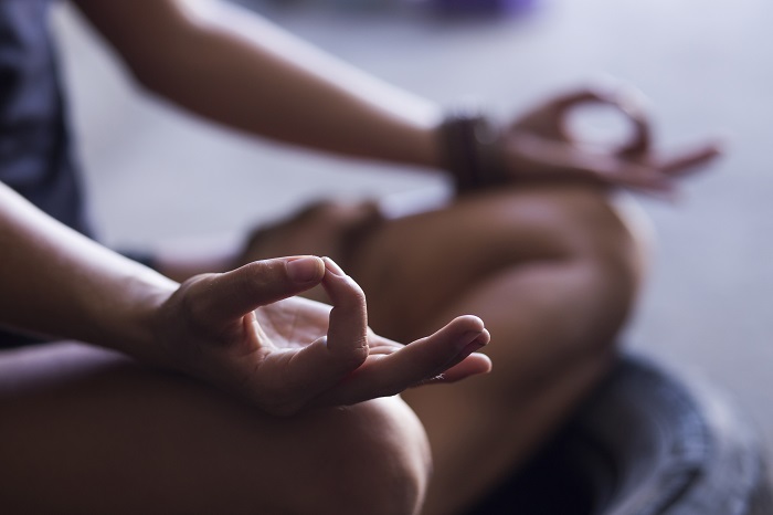 This is an image of a person meditating with their hands on their knees.