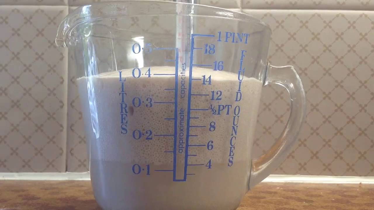 A close-up picture of a glass measuring cup on a kitchen counter. The cup is filled to above the 0.1 litre line with a cloudy light brown liquid. Above this a lighter coloured bubbly foam extends to nearly the 0.4 litre line.