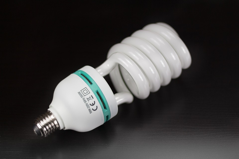This is an image of a fluorescent light bulb with a white ceramic base and a white frosted glass that is twisted into circles.