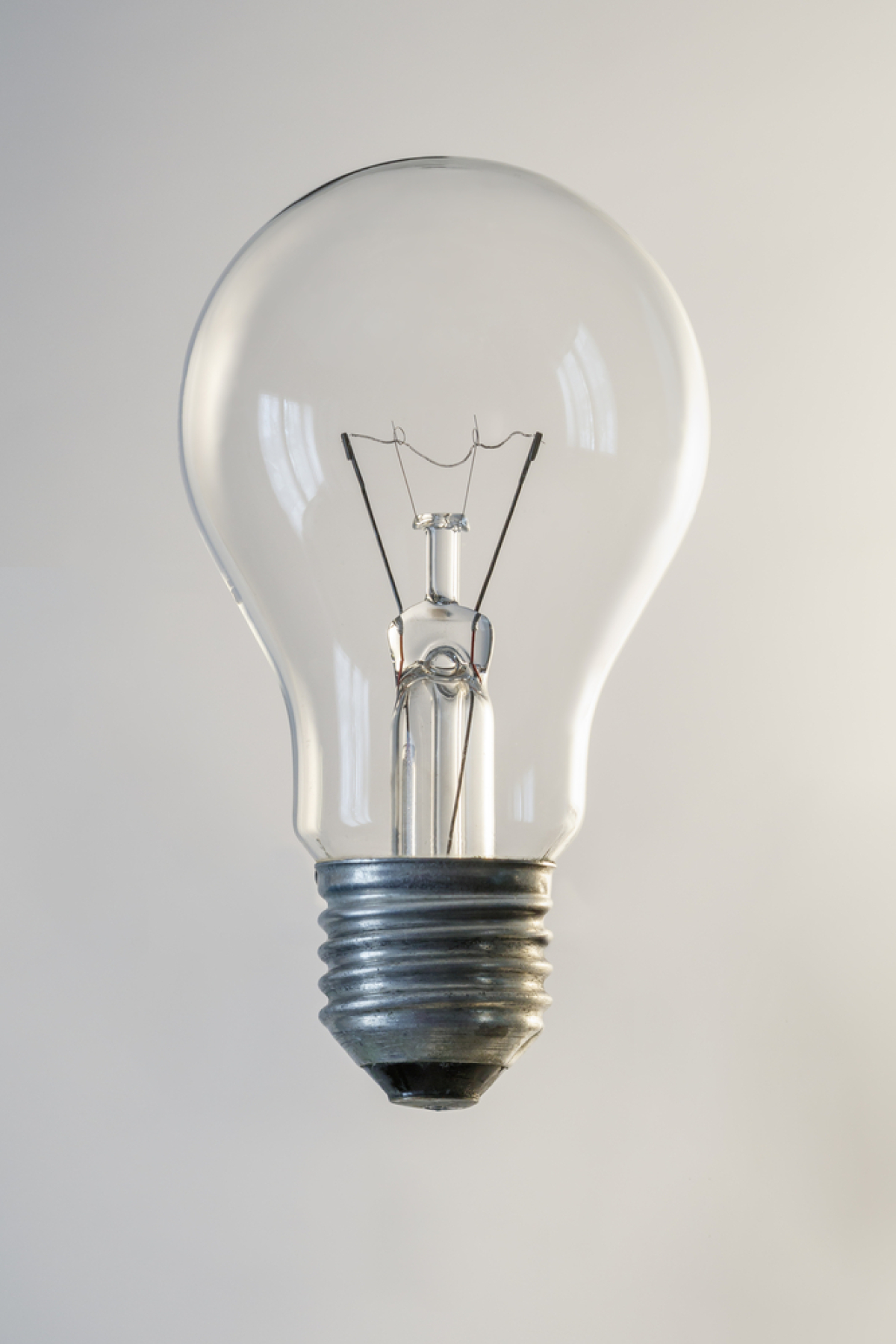 This is an image of a clear incandescent light bulb with a a filament in the centre.