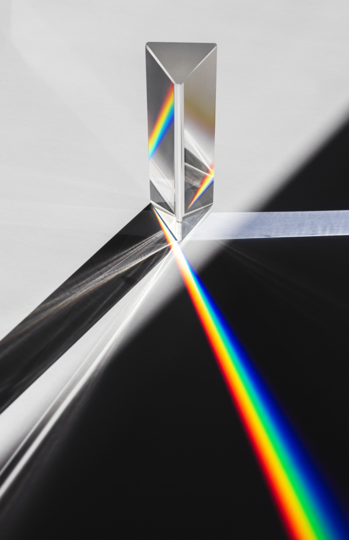 This image shows a beam of white light interacting with a glass prism. The prism splits the white light ray into a spectrum of colours (red, orange, yellow, green, blue, indigo and violet).