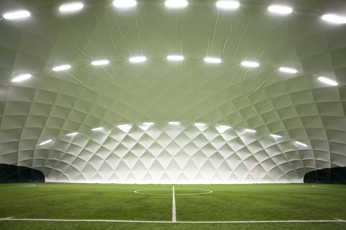 This is a photo of an indoor football field. Its roof is an enormous white dome.