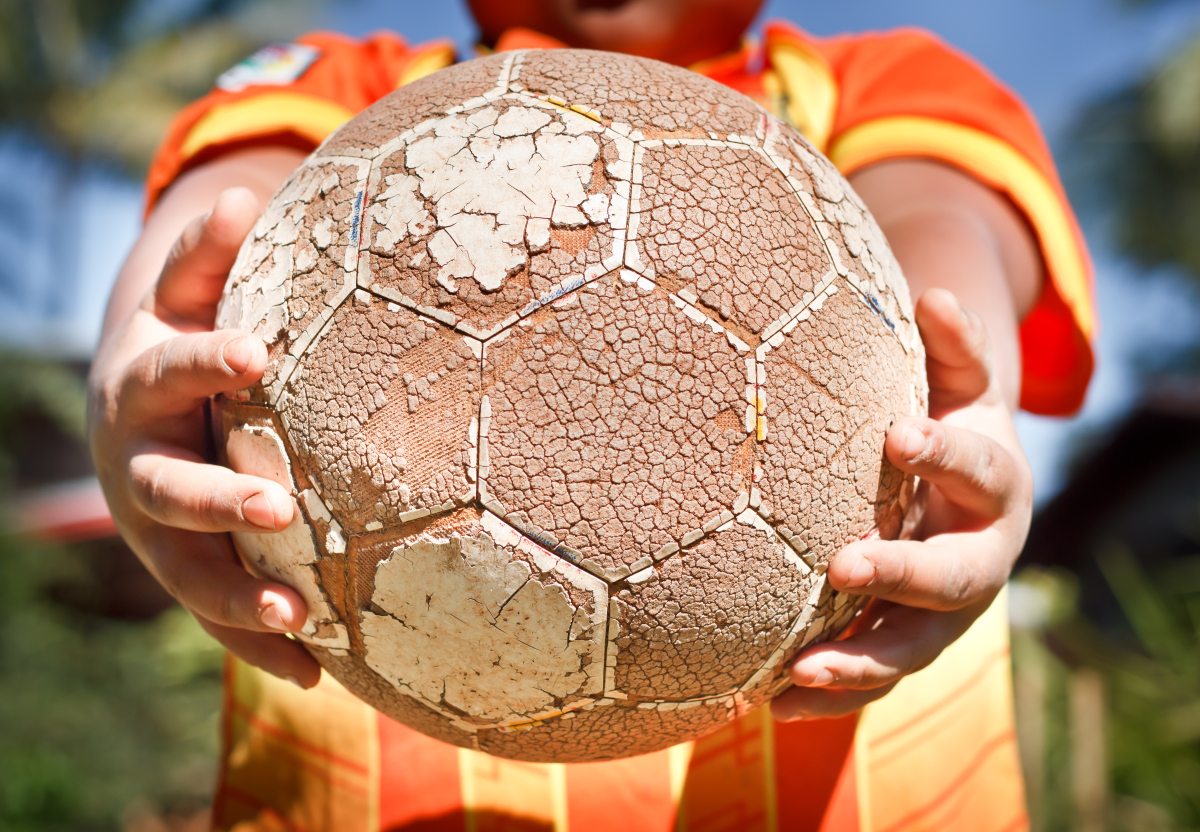 This is an image of a person holding a ball, preparing to drop it.