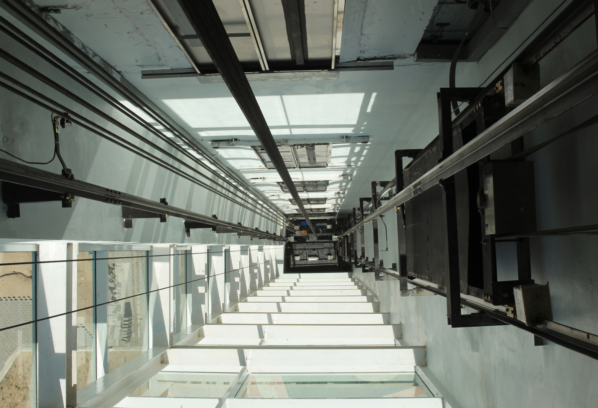 This image depicts the view from inside an elevator shaft looking down on the carriage.