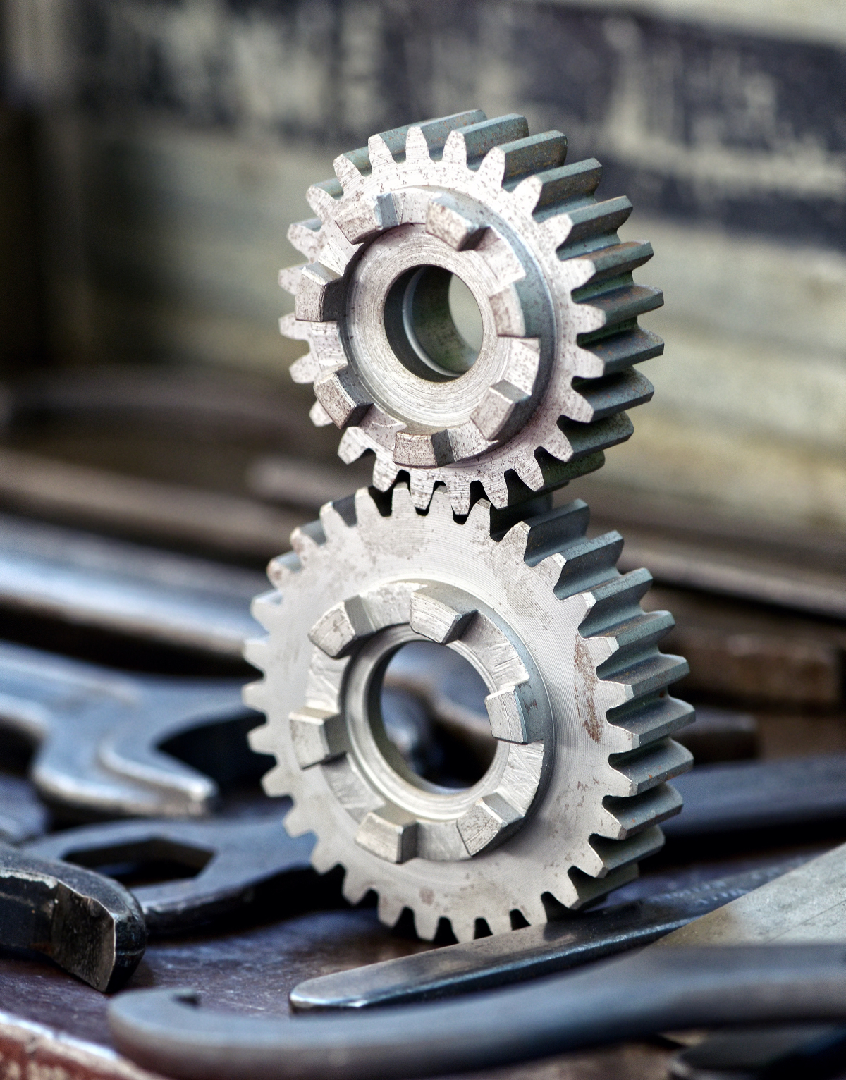 This image depicts a large metal 30 toothed-wheel interlocked to a smaller metal 24 toothed-wheel.