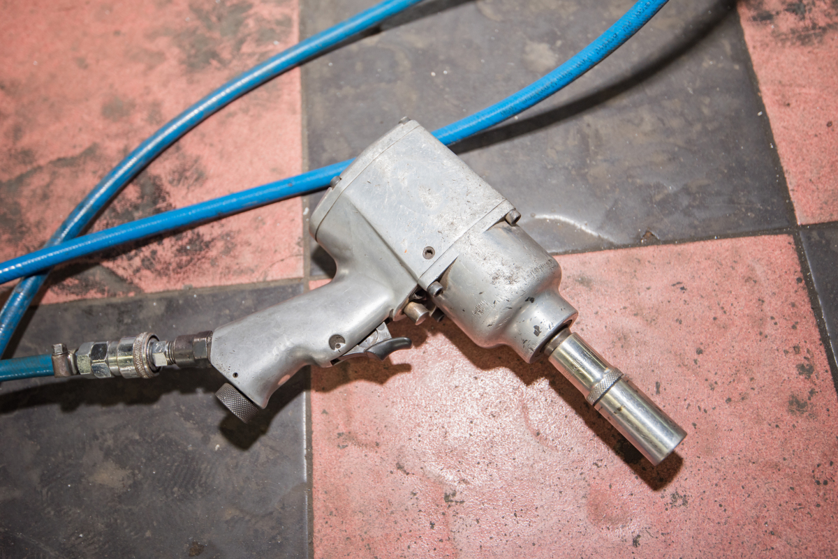 This image depicts a pneumatic wrench attached to a transmission line.