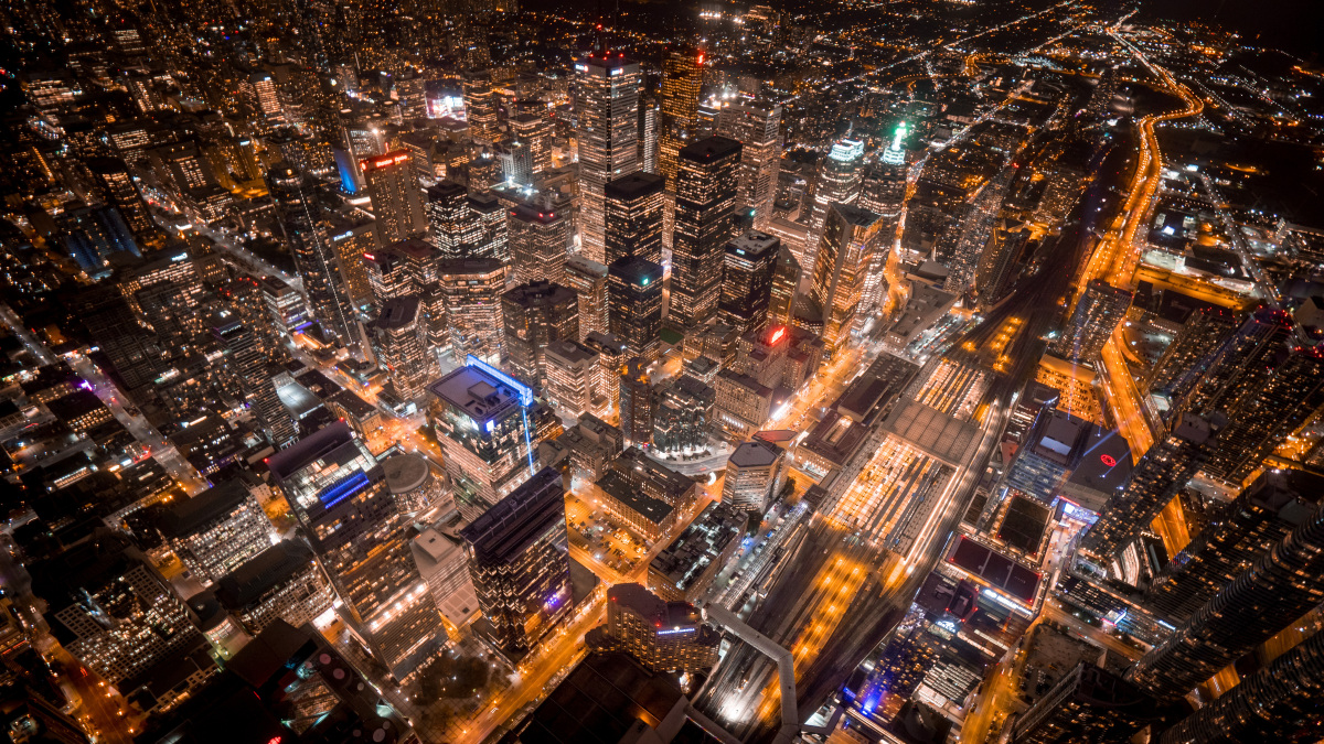  This aerial image depicts a city with streets and buildings lit up at night. 