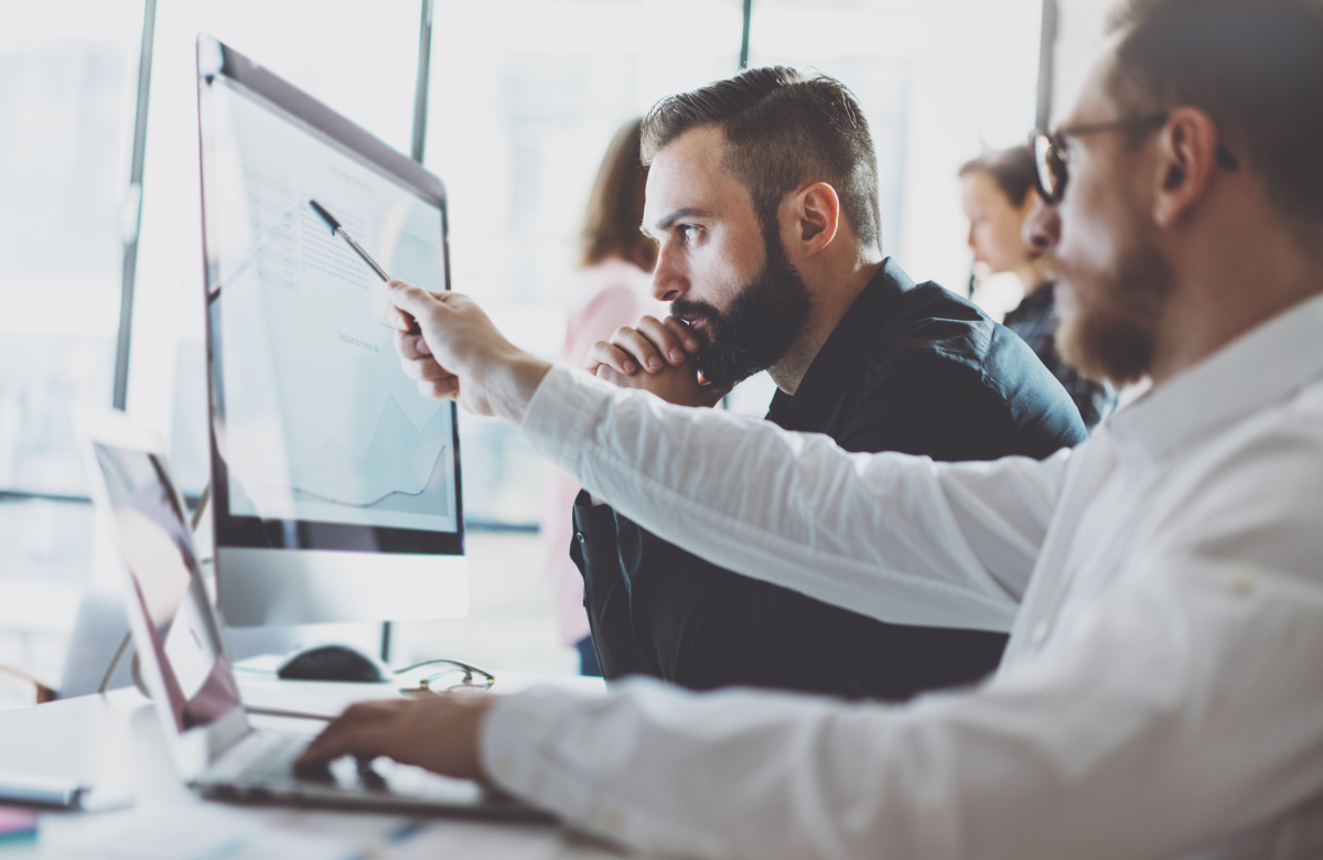 This image depicts workers using a computer in an office.