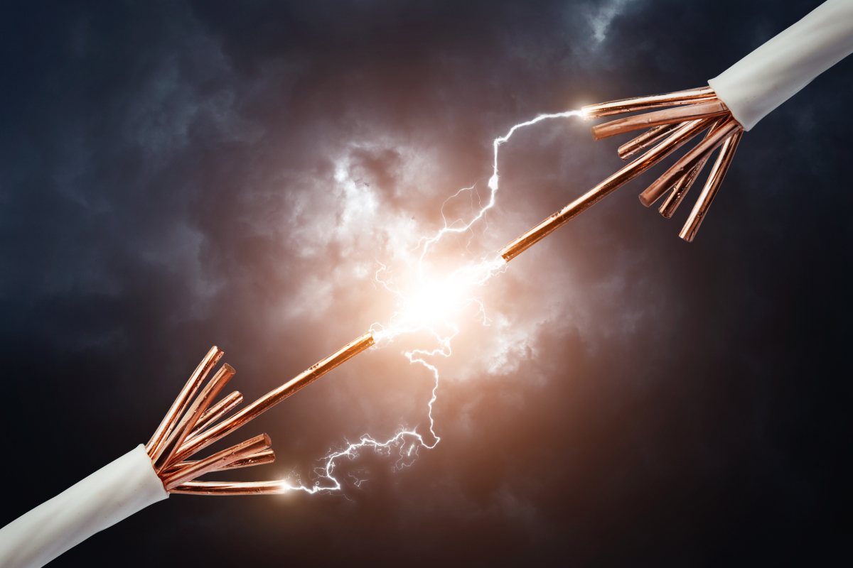 This image depicts a spark jumping between two electrical cables 