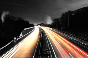 This is a photograph of the view from the windshield of a car while travelling very fast on a highway.