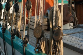 This is a photograph of the pulleys and ropes on a large sailboat.